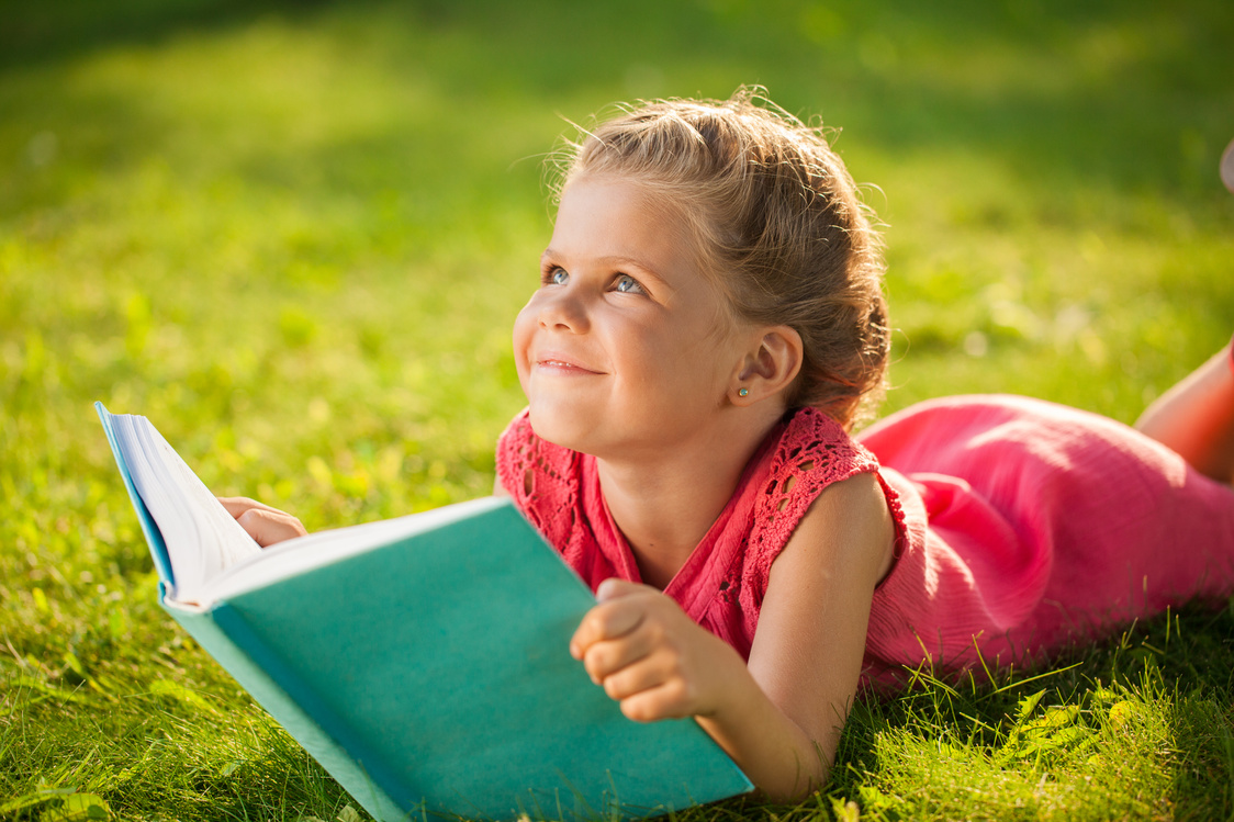 Girl Reading On Grass